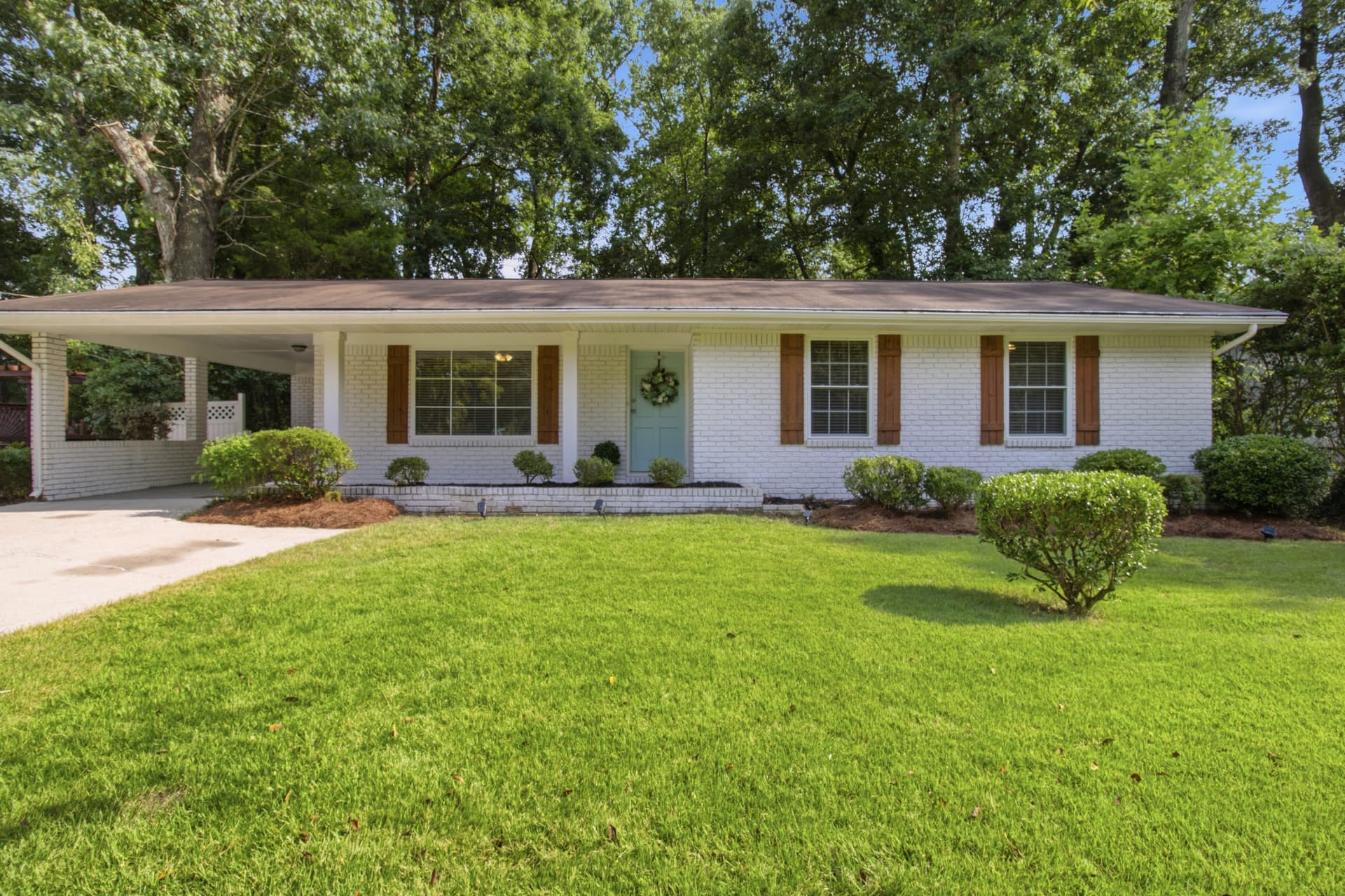 Front exterior of 2725 Bradmoor Way, a white brick ranch with carport in Decatur, Georgia